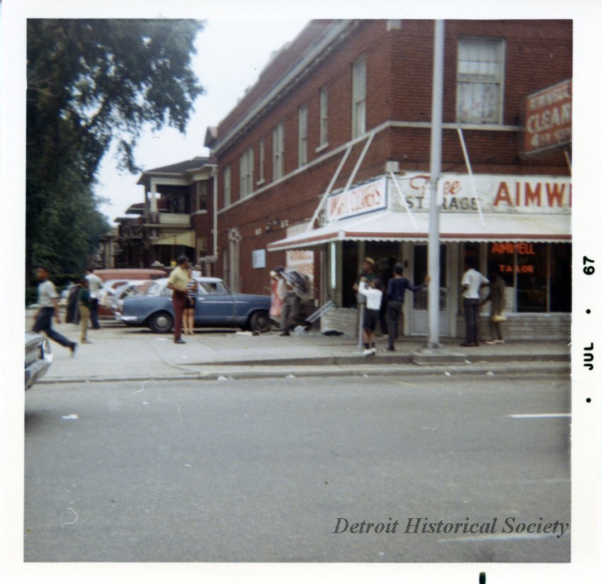 Color photo depicting Aimwell Cleaners at 12 St. and Atkinson Avenue during the 1967 Civil Disturbance, 1967 – 2018.076.031