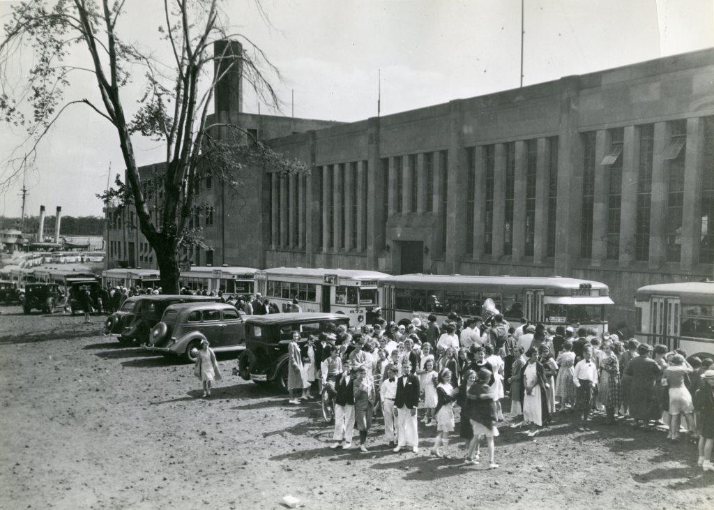 Students gathered along the East side of the building, 1930s.