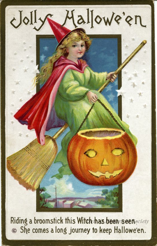 Color embossed postcard depicting a witch riding a broom and holding a jack-o'-lantern. Printed below the image: Riding a broomstick this Witch has been seen, She comes a long journey to keep Hallowe'en.