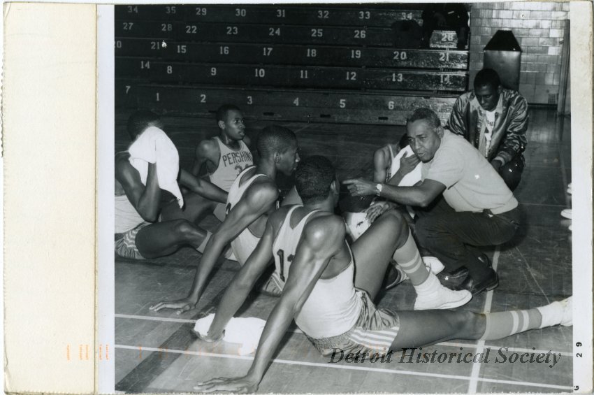 Photo of Coach Will Robinson with Pershing HS basketball players during game against Denby HS, c.1965 – 2008.102.999