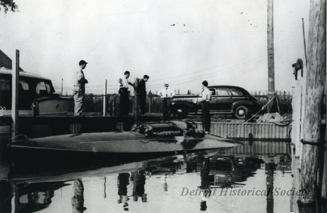 Photograph likely showing John Hacker looking over one of his boats, 1948